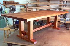 a large wooden table in a shop surrounded by tools