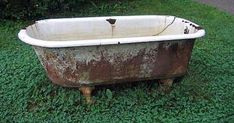 an old bath tub sitting in the grass