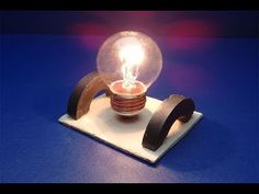 a small light bulb sitting on top of a wooden stand with a blue surface in the background