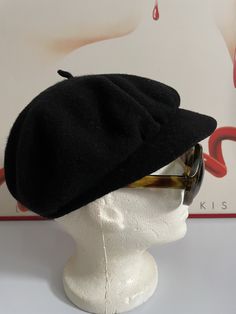 a white mannequin head wearing a black hat and sunglasses on it's head