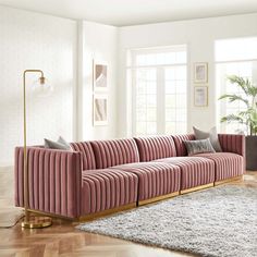 a living room with pink velvet couches and rugs on the wooden flooring