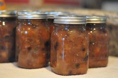 four jars filled with food sitting on top of a table