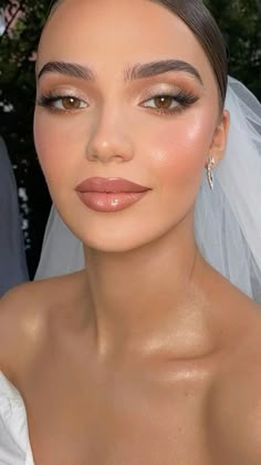 a woman in a wedding dress with makeup on her face and veil over her head