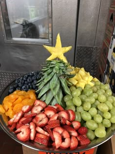 a fruit platter with pineapples, grapes, strawberries and other fruits