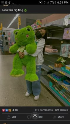 a woman holding a large green teddy bear in a grocery store with the caption, look this big frog