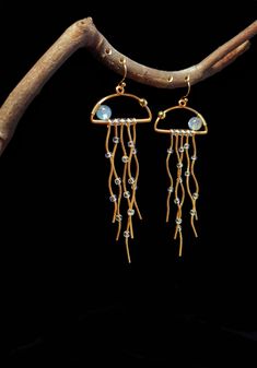 a pair of gold - plated earrings with crystal beads and dangling jellyfishs