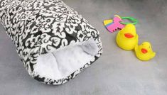 two yellow rubber ducks sitting next to a black and white animal print blanket on the floor