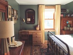 a bed room with a neatly made bed next to a dresser and a mirror on the wall