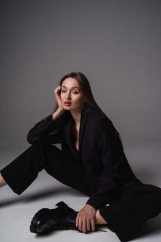 a woman sitting on the ground with her legs crossed