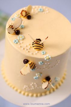 a three layer cake decorated with bees and flowers