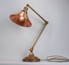 an old fashioned desk lamp with a cord attached to the base and one light on top