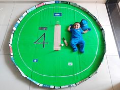 Baby photoshoot idea for monthly birthday celebration at home. My IPL#Cricket theme baby photoshoot idea is for my baby girl Shriya. She completed 4months during IPL, so it was a good idea with 4 Runs in a cricket match. 
I made the pitch from cardboards and green and brown cardpaper. The boundary with black cardpaper and as we see the ongoing advertisements at stadium I took the printouts of all baby products for the add. And the bat ball were made out of thermocol to meet the size of my baby. Ipl Theme Photoshoot, Cricket Theme Photoshoot, 1 Month Photoshoot Ideas, 4 Months Baby Photoshoot Ideas