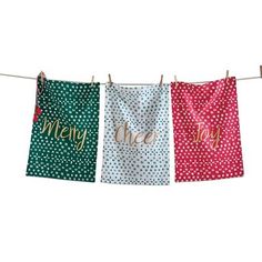 three tea towels hanging on a clothes line with the words, merry and one above them