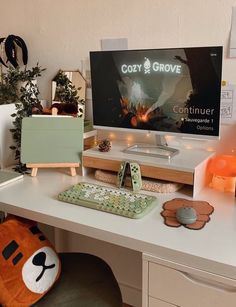 a desk with a computer monitor, keyboard and stuffed animals on it's side