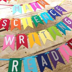 some colorful paper letters are hanging on a wooden floor