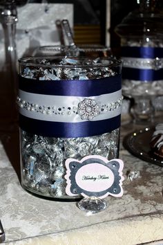 a jar filled with lots of silver and blue candies on top of a table