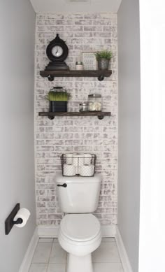 a white toilet sitting in a bathroom next to a shelf filled with towels and other items