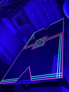 a neon colored object in the middle of a room with blue walls and purple lighting