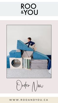 a man sitting on top of a pile of mattresses in front of a white wall