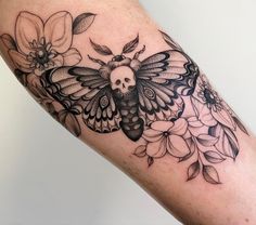 a black and white photo of a butterfly with flowers on it's back leg