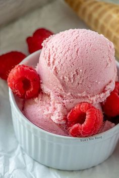 two scoops of ice cream with raspberries in a bowl