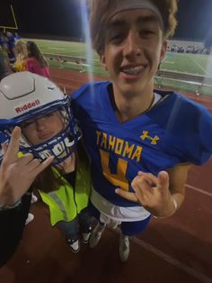 two people posing for a photo at a football game