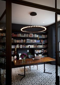 an image of a room with bookshelves on the wall and a table in the middle