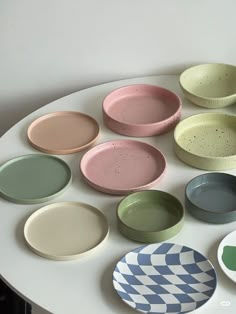 many different colored plates on a white table