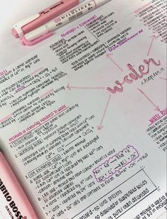 a pink pen sitting on top of a paper with the word written in it and two smaller pens next to it