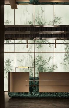 a bath tub sitting in front of a window next to a wall with bamboo leaves on it