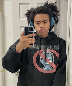 a young man wearing headphones is taking a selfie in front of a mirror