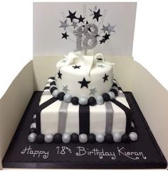 two tier cake with stars on top and black and white stripes around the edges, sitting in a box