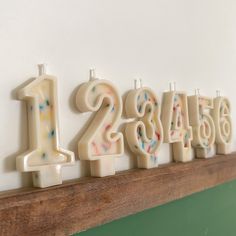 birthday candles are arranged in the shape of numbers on a mantel with frosting and sprinkles