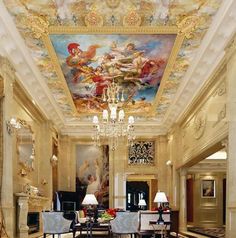 an elegant dining room with chandelier and paintings on the ceiling, along with marble flooring