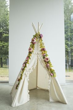 a teepee is decorated with flowers and leaves