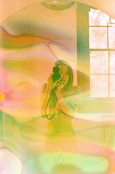 a woman holding a camera in front of a window