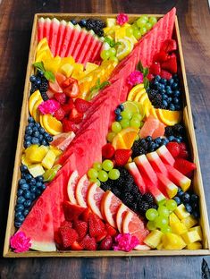 a wooden tray filled with cut up fruit