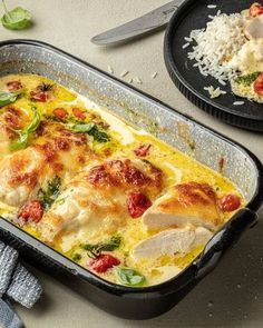 a casserole dish with chicken, tomatoes and spinach in it next to a plate of rice