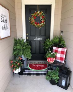 the front porch is decorated for christmas with wreaths and potted plants