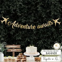 there is a cake and cupcakes on the table next to each other with an adventure await banner above it