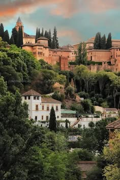 an old town on top of a hill surrounded by trees