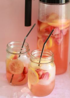 two mason jars filled with lemonade and strawberries