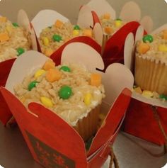 several cupcakes in red paper bags with candy on the top and one is filled with rice krispy kreme