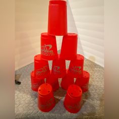 a stack of red plastic cups sitting on top of a table next to a wall