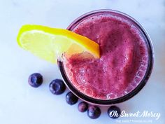 a blueberry smoothie with a lemon wedge on top