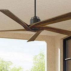 a ceiling fan that is mounted to the side of a wall next to a window