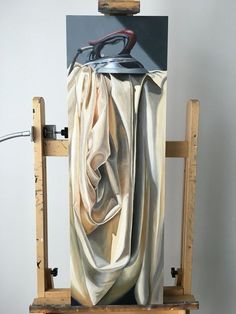 an artist's easel with a piece of cloth draped over it and a pair of scissors on top