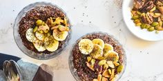 two bowls filled with granola topped with banana slices and pistachios next to each other