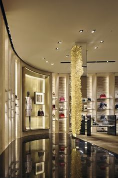 the inside of a shoe store with many shoes on shelves and lights hanging from the ceiling