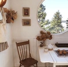 a white table and chair in front of a round window